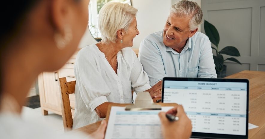 Ett äldre par går igenom sin hembudget på en laptop inför en låneansökan.