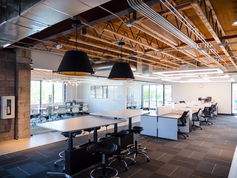 Modernt coworking-kontor med öppen planlösning och industriell design.